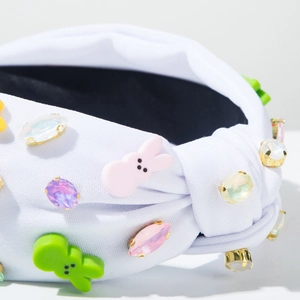 Detail of white knotted headband with sparkling rhinestones and cute bunny embellishments