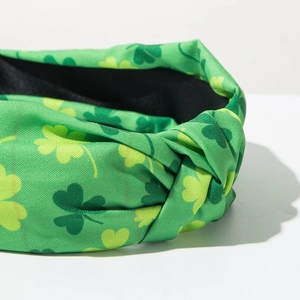 Detail of St. Patrick's Day headband with green shamrock pattern and top knot detail