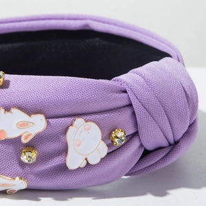 Détail du bandeau torsadé violet avec des breloques lapin et des strass étincelants