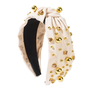 Padded knot headband in beige fabric with gold beads and amber crystals on white background