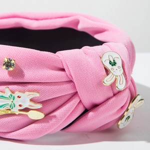 Détail du serre-tête rose texturé avec des breloques lapin en émail et un cristal