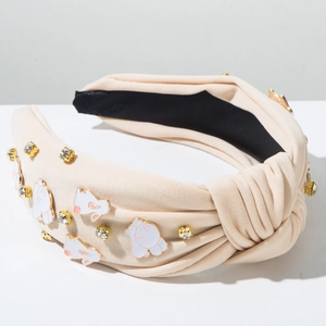 Détail d'un serre-tête noué beige avec des motifs de lapins et des strass étincelants