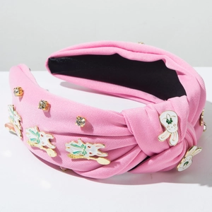 Détail du serre-tête rose noué orné de mignons lapins blancs et de strass brillants