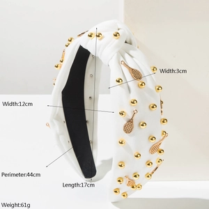 Détail du serre-tête noué blanc avec perles dorées et breloques raquette de tennis