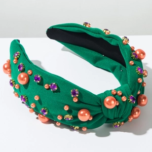 Détail du bandeau noué vert orné de perles oranges et de pierres précieuses mauves