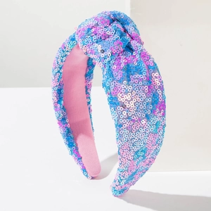 Macro-opname van stijlvolle brede geknoopte haarband met blauwe en roze glimmende lovertjes
