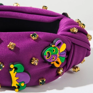 Gros plan sur un bandeau en tissu violet avec patchs de clown colorés et strass facettés