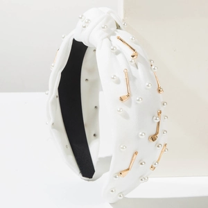 Détail du bandeau noué blanc avec perles et accessoires de club de golf dorés