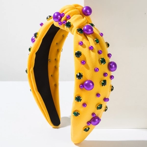 Détail macro du bandeau jaune avec perles mauves et strass en cristal vert brillant