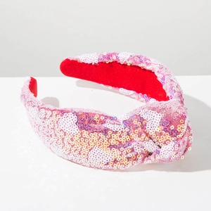 Close-up of pink and yellow sequined knotted headband with soft red velvet lining details
