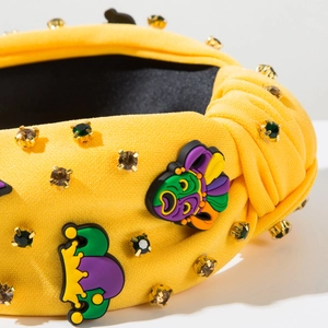 Gros plan du serre-tête noué jaune avec des couronnes de Mardi Gras et des strass