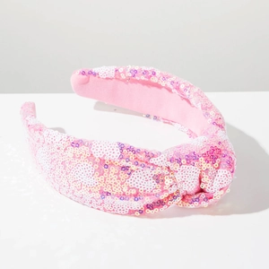 Close-up of pink knotted headband featuring shimmering colorful sequins and soft fabric