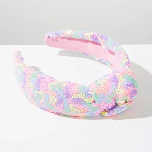 Detail van sprankelende gekleurde lovertjes en knoop op de brede gewatteerde haarband