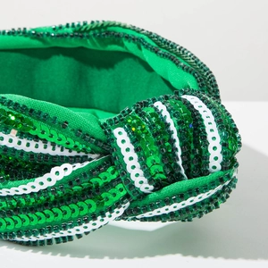 Detail of green and white sequins with dark green beads on a knotted festive headband
