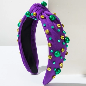 Détail d'un serre-tête violet à nœud orné de perles vertes et strass jaunes