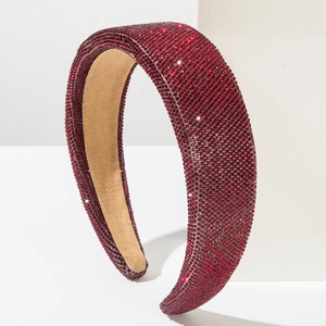 Detail view of red rhinestone padded headband with premium khaki velvet lining texture