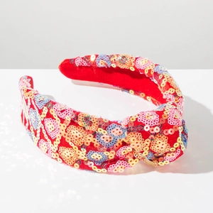 Detail of red sequin headband with colorful diamond patterns and knotted top design