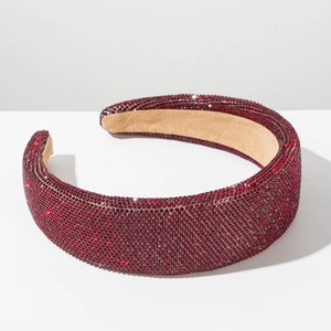Detailed macro view of a red rhinestone padded headband with sparkling crystal embellishments