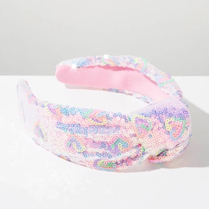 Close-up of pink knotted headband featuring macaron-colored sequins and heart patterns