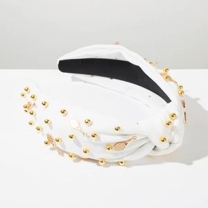 Détail d'un serre-tête noué blanc avec des perles dorées et pendentifs de raquette