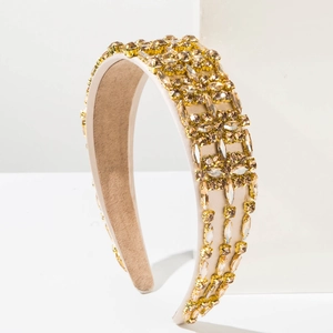 Detail of baroque headband with amber crystals and champagne fabric on a white base