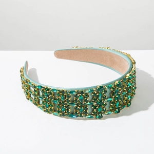 Detail of vintage Baroque headband with green crystals in a geometric gold setting