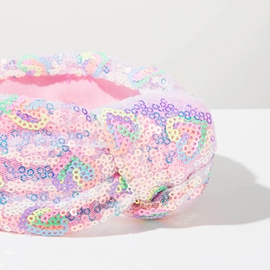 Close-up of pink headband knot featuring vibrant multi-color sequins and texture