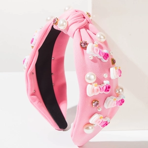 Nahaufnahme von rosa geknotetem Haarband mit Perlen, Strass und 3D-LOVE-Dekorationsbuchstaben