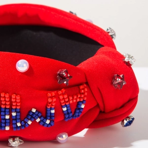 Détail du bandeau rouge noué avec broderie de perles complexe et strass brillants décoratifs