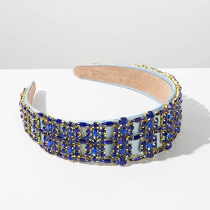 Detailed macro view of deep blue crystals hand-set on a light blue satin headband
