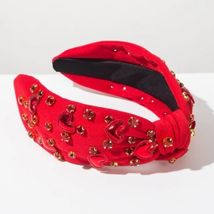 Detailansicht des roten geknoteten Stirnbands mit Strassherzen und festlicher Textur