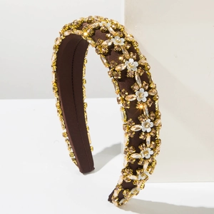 Detailed shot of wide padded headband featuring crystals and white floral embellishments