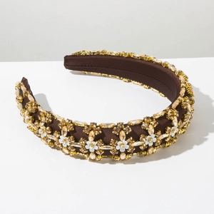 Detail of vintage padded headband with amber crystals and small white enamel flowers