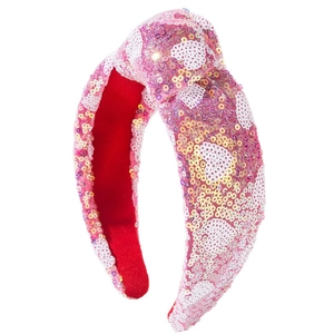 Pink sequin knotted headband with white heart patterns and soft red lining on white background