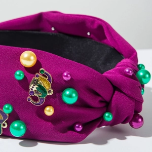 Close-up of purple knotted headband with circus elephant charm and colorful pearls