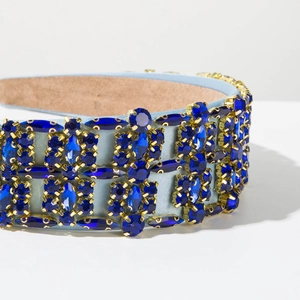 Close-up of luxury Baroque headband with deep blue crystals in golden claw settings
