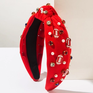 Detail of red knotted headband with white pearls, rhinestones, and rugby charms