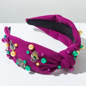 Detail of beaded purple carnival headband with green pearls and festive mask charms