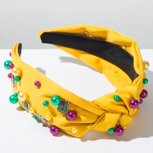 Detail of yellow knotted Mardi Gras headband with colorful pearls and metal charms