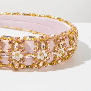 Detail of pink satin headband with encrusted crystals and white enamel flower petals