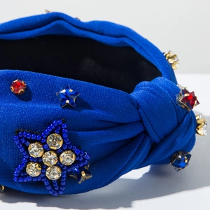 Detail of royal blue knotted headband with beaded star patch and colorful rhinestones