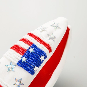 Détail de la décoration drapeau américain perlé avec étoiles argentées sur serre-tête