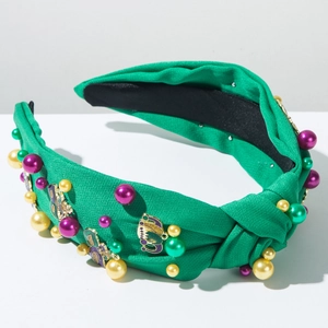 Detail of green carnival headband with colorful pearls and enamel mask charms