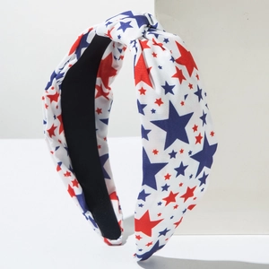 Détail du bandeau large noué avec des étoiles rouges et bleues sur un tissu blanc