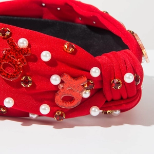 Détail du serre-tête noué rouge avec sequins XOXO, perles et strass rouges brillants