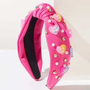 Detail of rose pink knotted headband with heart resin, pearls and crystals decor