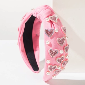 Detail of pink knotted headband with sparkling rhinestone hearts and white faux pearls