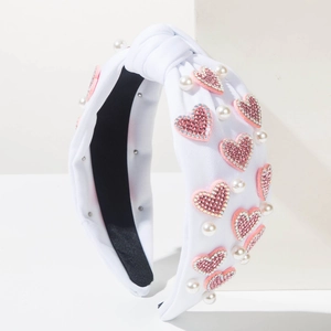 Knot headband with pink rhinestone hearts and white pearls on elegant white fabric