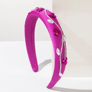 Serre-tête élégant en satin violet avec strass brillants et perles sur support blanc