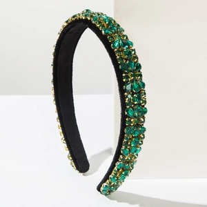 Detailed macro view of emerald green crystal headband with gold claw setting